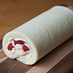 An unsliced strawberry roll cake